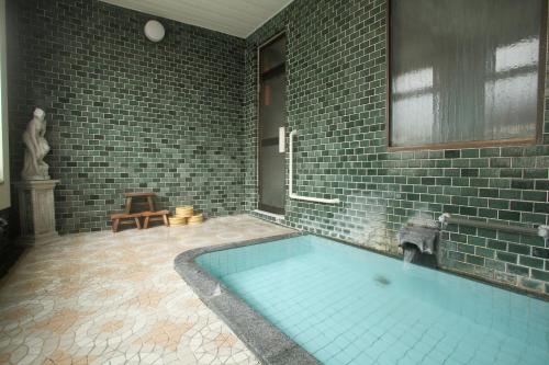 鹤冈市雅司旅馆的一间带砖墙大浴缸的浴室