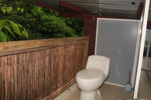 圣玛尔塔Glamping Bio Coliving Tayrona的浴室设有卫生间,毗邻木栅栏
