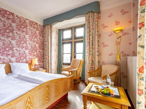 Staufenberg斯多分伯格酒店的一间卧室配有一张床和一张桌子,上面放着水果盘