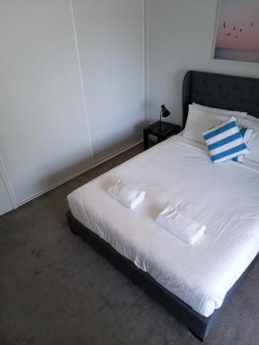 玛志洛马卢奇金沙假日公寓酒店的白色的床和蓝色的白色枕头
