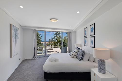 安特兰斯Coast Luxury Apartments 17的白色的卧室设有床和大窗户