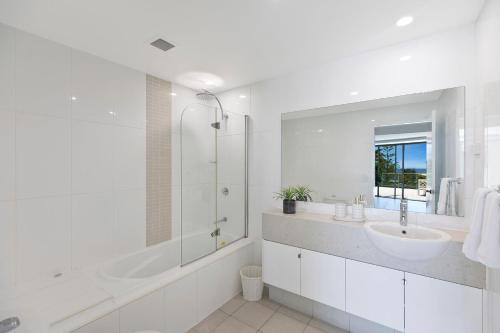 安特兰斯Coast Luxury Apartments 17的白色的浴室设有水槽和淋浴。