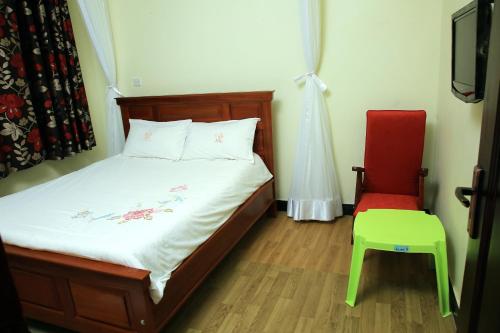 恩德培St. Patrick’s Forest House的一间卧室配有一张床和一张红色椅子