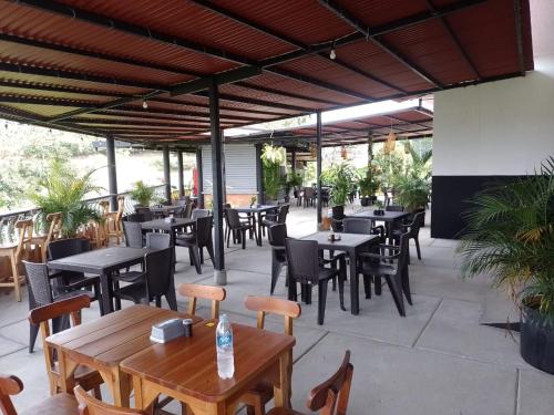佩雷拉Hotel Maranta的一个带桌椅的户外庭院和一间餐厅