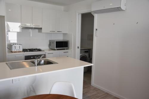 Capel SoundPeninsula Beachside Accommodation的厨房配有白色橱柜和水槽