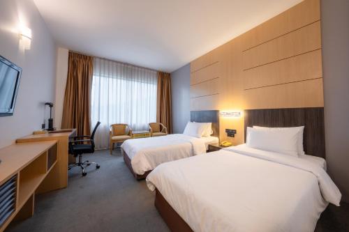 曼谷阿里斯顿酒店曼谷的酒店客房设有两张床和电视。