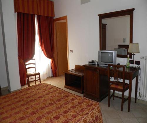 奥瓦达贝拉焦酒店的一间卧室配有一张桌子、一台电视和一张书桌及一台电脑