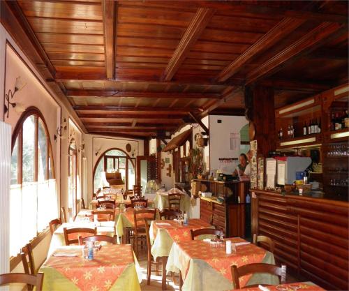 奥瓦达贝拉焦酒店的餐厅设有桌椅和木制天花板。