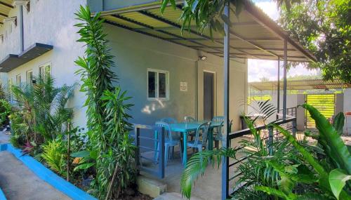 圣胡安Hidden Palms Inn/Resort La Union的一个带蓝色桌子和一些植物的庭院