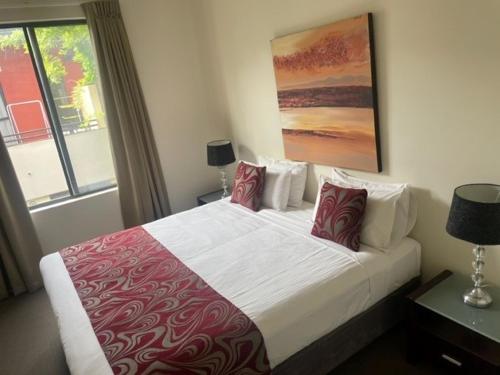 阿德莱德阿德莱德RNR服务式公寓 - 斯特尔特街的一间卧室配有一张带红色和白色枕头的大床