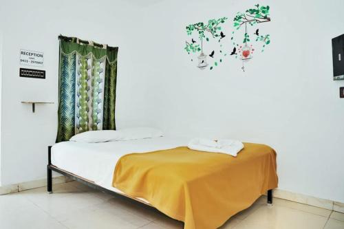 蓬蒂切里Paradise Feel Dreamy Resort的一间卧室配有一张黄色床单