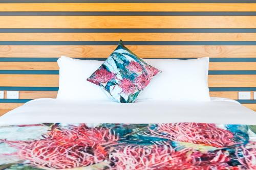 霍尔布鲁克Holbrook Motel的床上有色彩缤纷的毯子和枕头