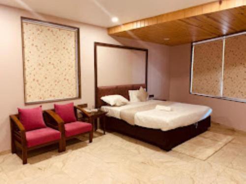阿南德HOTEL RADHE Anand的一间卧室配有一张大床和两把椅子