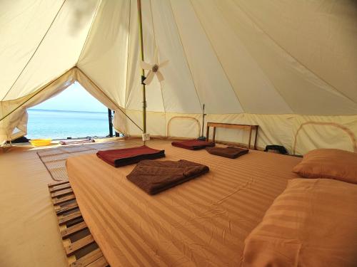 高龙撒冷岛KAMAKU Bungalows的帐篷内的一张床位,上面有两条毛巾