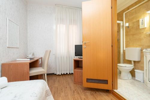 博洛尼亚多纳泰罗酒店的一间卧室配有一张床、一个卫生间和一台电视。