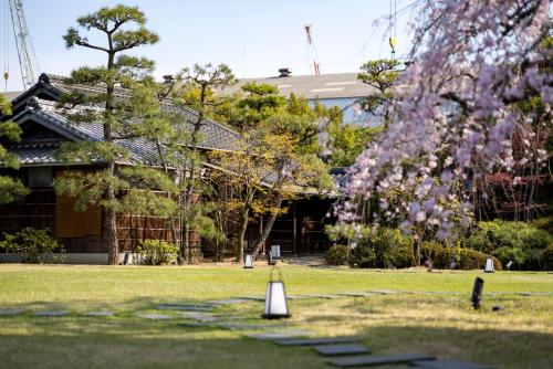 尾道市Ryokan Onomichi Nishiyama的建筑前有锥体的院子