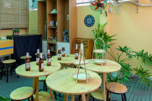 胡志明市Saigon Authentic Hostel - Cozy Rooftop, Family Cooking Experience, FREE Walking Tour, Vietnamese Breakfast & Gym的一间设有木桌和瓶子的房间