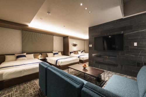 鹿儿岛GRAND BASE Kagoshima Tenmonkan的酒店客房设有两张床和一台平面电视。