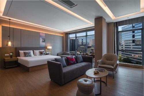深圳深圳西丽创新谷亚朵酒店的酒店客房,配有床、沙发和椅子