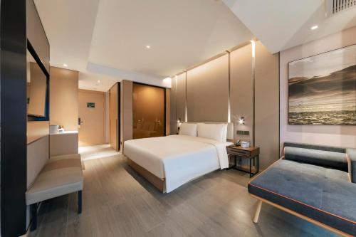 桂林桂林两江四湖象鼻山亚朵酒店的卧室配有白色的床和沙发