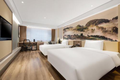 重庆重庆解放碑亚朵酒店的酒店客房设有三张床和电视。