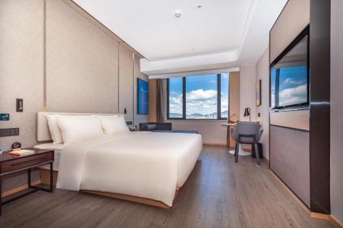 昆明昆明人民西路大观亚朵酒店的酒店客房设有一张白色大床和一张书桌