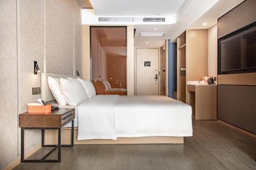 昆明昆明国贸中心亚朵酒店的卧室配有一张白色的大床和一张桌子