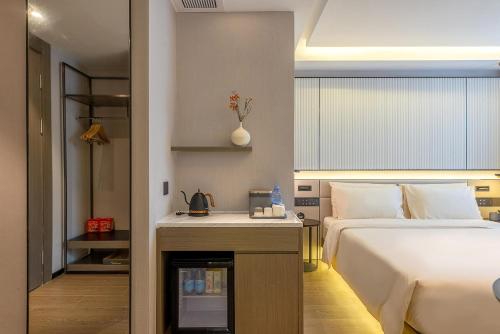 深圳Atour S Hotel Shenzhen Futian Port的酒店客房设有一张床铺和一张带壁炉的桌子。