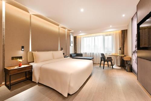 北京北京安贞亚朵S酒店的酒店客房设有一张白色大床和一张书桌