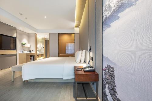 成都成都文殊坊亚朵酒店的卧室配有一张白色的大床和一张桌子