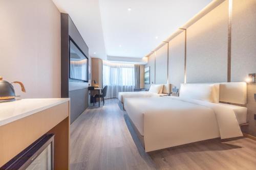 滨海新区天津滨海三大街MSD亚朵酒店的酒店客房配有两张床和一张书桌