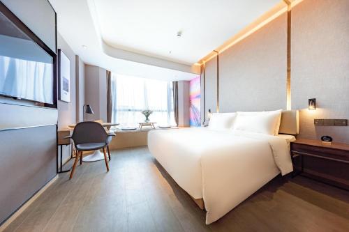 深圳深圳华强北亚朵酒店的酒店客房设有一张大床和一张书桌。