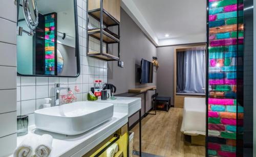 青岛青岛山东路中央商务区亚朵轻居酒店的浴室设有白色水槽和镜子