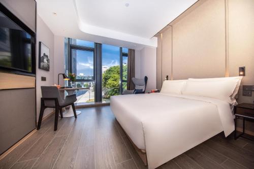 上海上海五角场大学路亚朵酒店的卧室配有一张白色大床和一张书桌