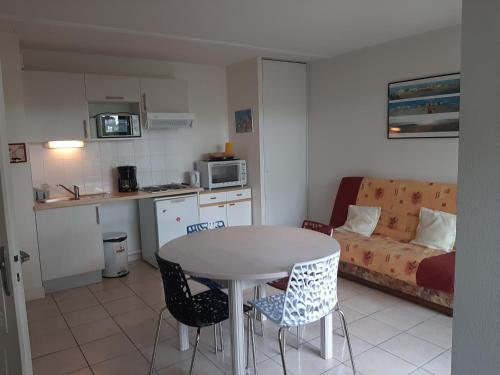 卡布勒通Appartement Capbreton, 3 pièces, 4 personnes - FR-1-239-453的厨房以及带桌椅的起居室。