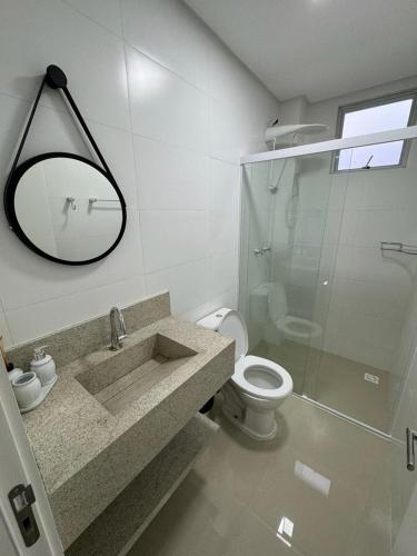 伊塔佩马Apartamento à 390m do Mar的一间带水槽、卫生间和镜子的浴室