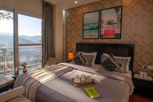 西姆拉PerfectStayz Shimla的一间卧室设有一张大床和一个大窗户