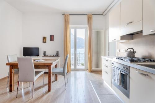 托尔博莱Lake Sensation - Garda Lake View的一间带木桌的厨房和一间餐厅