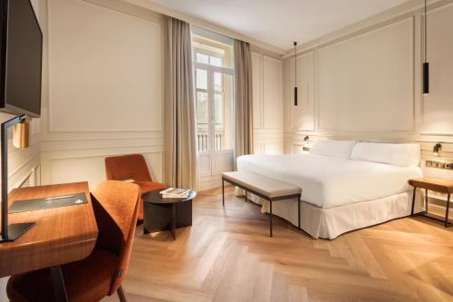 毕尔巴鄂Bilder Boutique Hotel的配有一张床和一张书桌的酒店客房