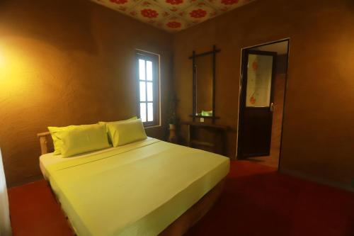 锡吉里亚Dinna Nature Hostel的一间卧室配有一张带白色床单的床和一扇窗户。