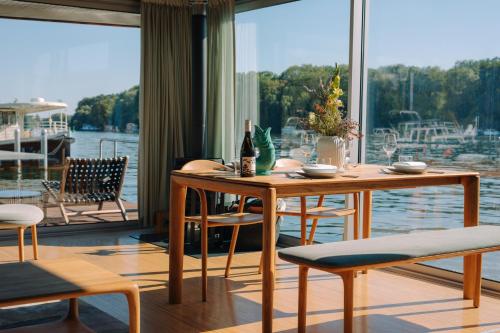 柏林JULIA - Schwimmendes Apartment的一间带桌椅和大窗户的用餐室