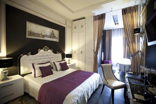 哈尔科夫Mirax Boutique Hotel的一间卧室配有一张床、一张桌子和一把椅子