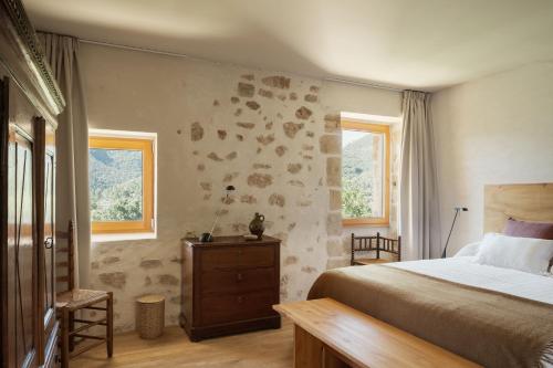 TrespaderneEl Priorato de Trespaderne的一间卧室设有一张床和两个窗户。