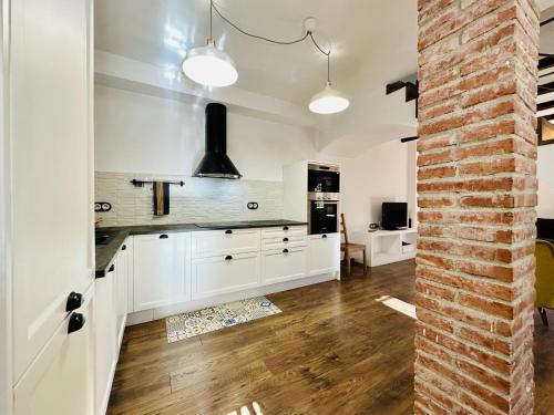 圣塔克里斯蒂纳阿鲁Agudes CostaBravaSi的厨房配有白色橱柜和砖墙