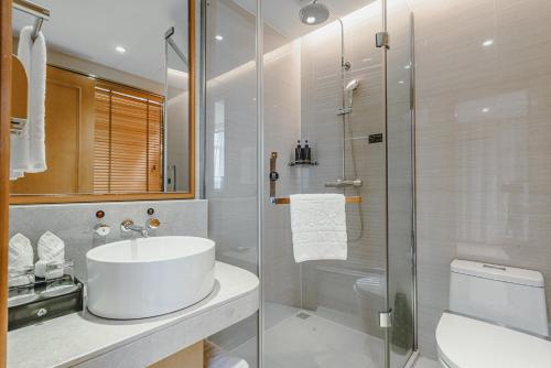 温州航宾国际大酒店的白色的浴室设有水槽和淋浴。