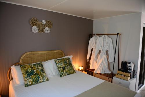 毕博纳的码头卡萨帝卡恰营地旅馆的卧室配有一张床,墙上挂着一连衣裙