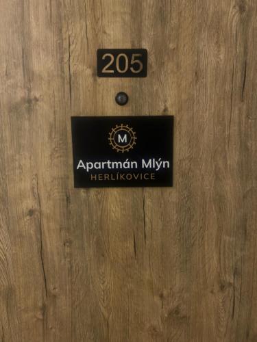 弗尔赫拉比Apartmán Mlýn Herlíkovice 205的木门前的标志