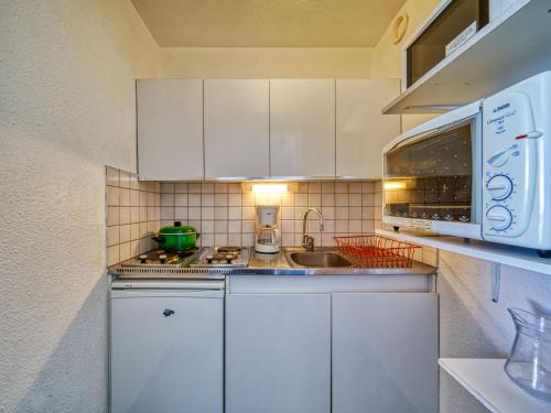 勒克比尔Apartment Lunik Orion-41 by Interhome的厨房配有白色橱柜、水槽和微波炉