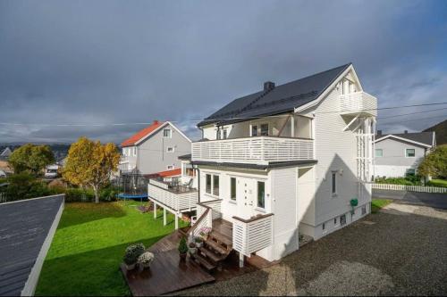 特罗姆瑟Tromsø’s best location? City & Nature 5 mins away.的黑色屋顶的白色房子