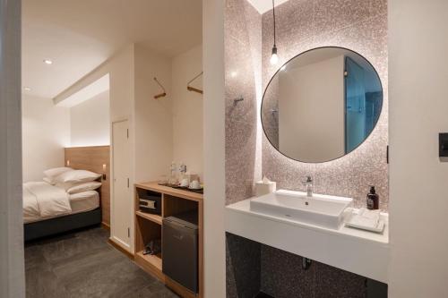 曼谷ZEN MASTER HOTEL的一间带水槽和镜子的浴室